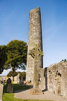 Fifth century monastic settlement at Monasterboice, county Louth in Ireland. View over the round tower and the Western High Cross. At over 6.5 m high this is the tallest celtic High Cross in Ireland.