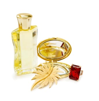 Luxury gift for the celebration of a special day with bottle of perfume, golden mirror and red ruby ring. Isolated over white background.