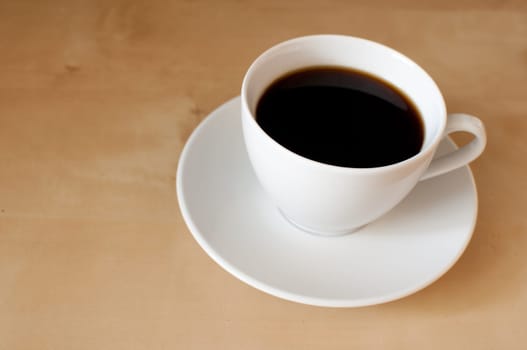 Espresso coffee in white mug on wooden table