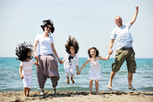 happy young family have fun and live healthy lifestyle on beach