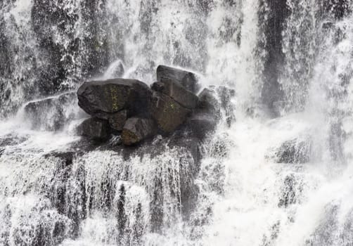 rocks in the middle of the waterfall