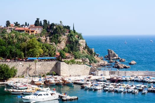 Famous old harbor in Antalya with boats, ships and yachts anchored in it.