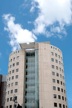 Unusual Round Office Block with External Elevator under a blue sky