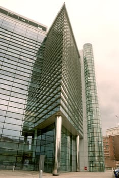Futuristic Triangular Office Block with stainless steel pillars and a glass walled elevator