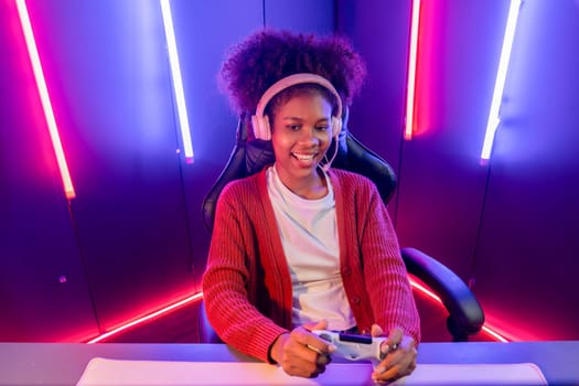 Host channel of gaming streamer, African girl wining with Esport skilled team player and viewers online game in neon color lighting room. Concept of cybersport indoor activities. Tastemaker.