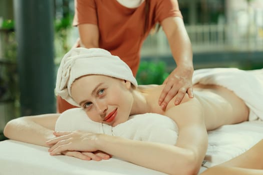 Couple of beautiful young woman lie on white spa bed during having back massage. Attractive caucasian woman having back massage at traditional spa room. Relaxing and healthy concept Tranquility.