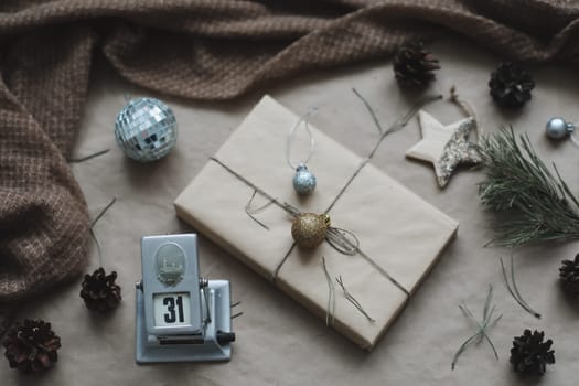 Christmas composition. Gift, fir tree branches, balls on craft paper background. Christmas, winter, new year concept. Flat lay, top view, copy space.