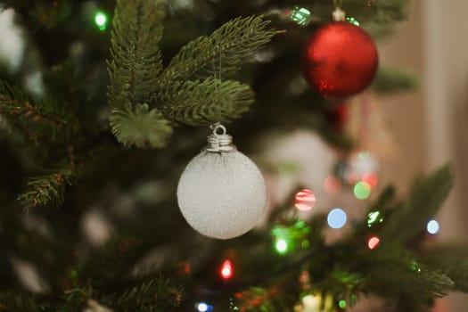 Christmas and New years eve Background. Close up of balls on christmas tree. Bokeh garlands in the background. New Year concept. Decorated Christmas tree on blurred, sparkling and fairy background