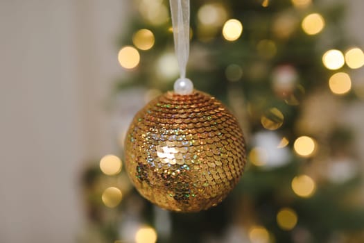 Christmas and New years eve Background. Close up of balls on christmas tree. Bokeh garlands in the background. New Year concept. Decorated Christmas tree on blurred, sparkling and fairy background