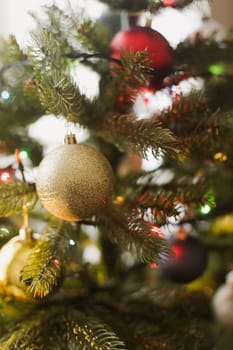 Christmas and New years eve Background. Close up of balls on christmas tree. Bokeh garlands in the background. New Year concept. Decorated Christmas tree on blurred, sparkling and fairy background