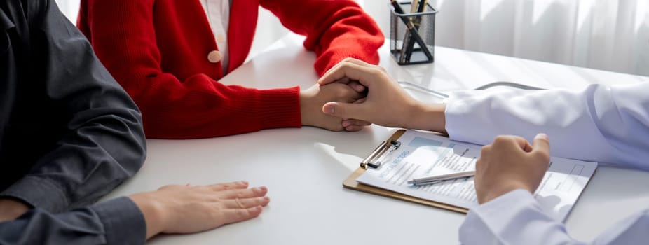 Couple attend fertility or medical consultation with gynecologist at hospital as family planning care for pregnancy while doctor and husband consoling young wife through appointment. Panorama Rigid