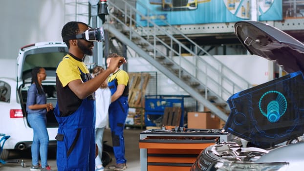 Qualified technician in repair shop using advanced virtual reality technology to visualize car mechanical component in order to fix it. Garage expert wearing vr glasses while repairing damaged vehicle