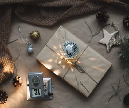 Christmas composition. Gift, fir tree branches, balls on craft paper background. Christmas, winter, new year concept. Flat lay, top view, copy space.