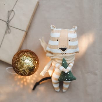 Christmas composition with a tiger toy, symbol of new 2022, a gift, fir tree branches and decorations. Christmas, winter, New year concept. Flat lay, top view.