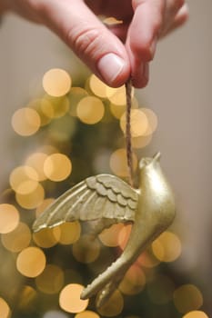 Decorating Christmas tree, holding Christmas toy in a hand. Holiday, Christmas and New Year family celebration concept.