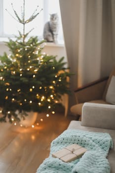 Christmas gift wrapped in craft paper under a tree. New Year card.