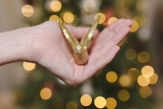 Decorating Christmas tree, holding Christmas toy in a hand. Holiday, Christmas and New Year family celebration concept.