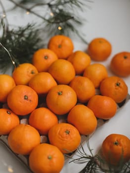 Christmas background with fir tree branches and tangerines. Merry Christmas and Happy New Year Greeting Card. Copy space. Top view. High quality photo