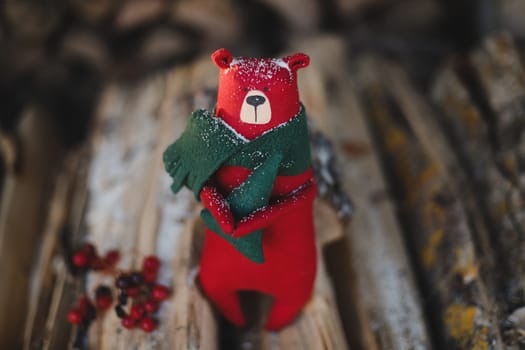 Christmas, New Year, Winter concept. Cozy composition with toy bear on wooden logs under snow.