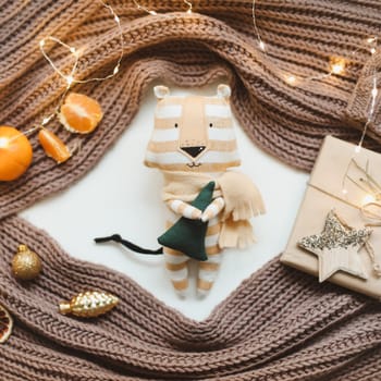 Christmas composition with a tiger toy, symbol of new 2022, a gift, fir tree branches and decorations. Christmas, winter, New year concept. Flat lay, top view.