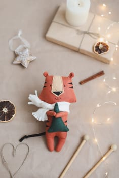 Christmas composition with a tiger toy, symbol of new 2022, a gift, fir tree branches and decorations. Christmas, winter, New year concept. Flat lay, top view.