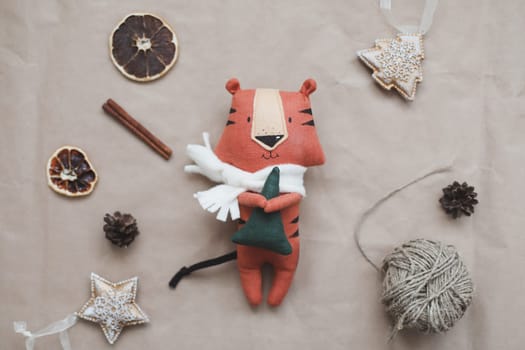 Christmas composition with a tiger toy, symbol of new 2022, a gift, fir tree branches and decorations. Christmas, winter, New year concept. Flat lay, top view.