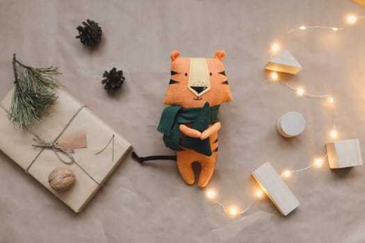 Christmas composition with a tiger toy, symbol of new 2022, a gift, fir tree branches and decorations. Christmas, winter, New year concept. Flat lay, top view.