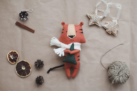 Christmas composition with a tiger toy, symbol of new 2022, a gift, fir tree branches and decorations. Christmas, winter, New year concept. Flat lay, top view.