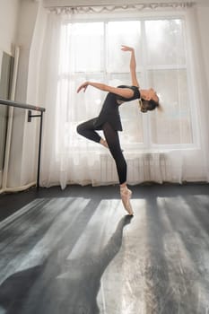 A beautiful Asian woman is dancing at the barre. Ballet dancer