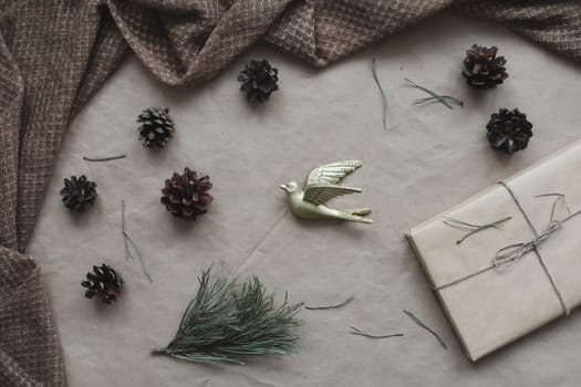 Christmas composition. Gift, fir tree branches, balls on craft paper background. Christmas, winter, new year concept. Flat lay, top view, copy space.