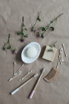 Soap bar or solid shampoo on a soap dish, bamboo toothbrush and towel top view with copyspace. Accessories for personal hygiene. Plastic free and eco friendly products in household.