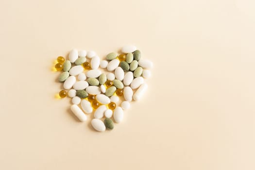 Flat lay Colorful Pile of Scattered Capsules, Pills, Vitamins in Heart Shape on Beige Background. Medical Supplements, Tablets or Drug Pharmaceutical Concept. Flatly. Health Insurance, Horizontal