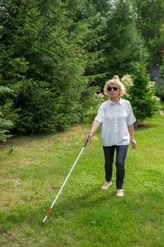 Elderly blind woman walking in the park