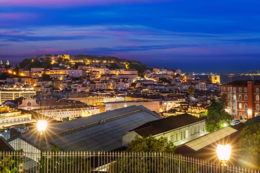 View of Lisbon famous view from Miradouro de Sao Pedro de Alcantara tourist viewpoint in the evening. Lisbon, Portugal. Camera pan