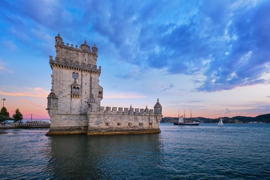 Belem Tower or Tower of St Vincent - famous tourist landmark of Lisboa and tourism attraction - on the bank of the Tagus River (Tejo) in evening dusk after sunset with dramatic sky. Lisbon, Portugal