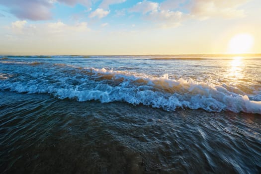 Atlantic ocean sunset with surging waves at Fonte da Telha beach, Costa da Caparica, Portugal