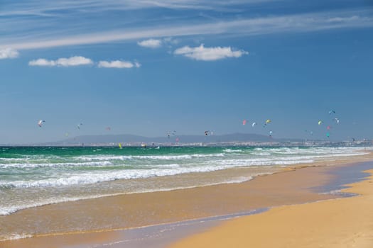 Kiteboarding kitesurfing kiteboarder kitesurfer kites on the Atlantic ocean beach at Fonte da Telha beach, Costa da Caparica, Portugal