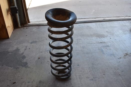 Working on offroad vehicle suspension system in my garage. Took the old spring out to add a spacer. High quality photo