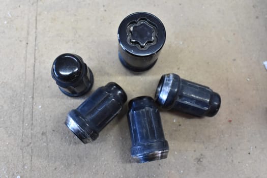 Five Lugnuts on Garage Floor, one with Special Locking Security Pattern. High quality photo