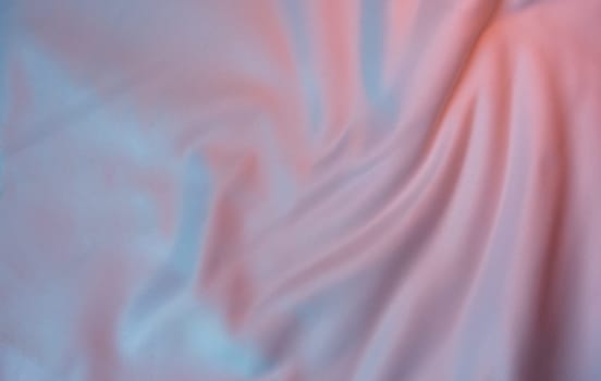 Light fabric with a pastel pink and blue gradient, featuring soft folds and a smooth texture. Ideal for backgrounds, templates, and design projects with copy space