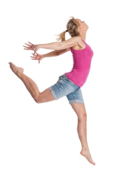 Young woman jumping in front of light background