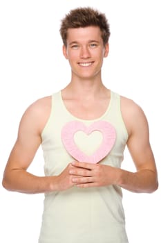 Studio shot of a young and happy man with a heart
