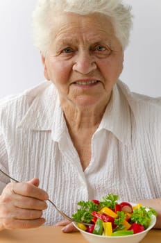 Senior woman eating vegetable salad