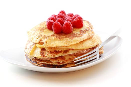 Sweet pancakes with fresh raspberries on white background