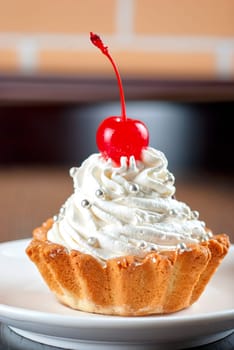 fresh baked cherry cupcake on a dark wooden background
