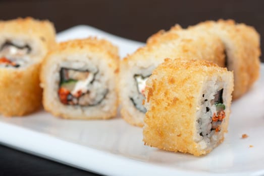 Sushi rolls made of rice, smoked eel, cream cheese and flying fish roe - tobiko caviar