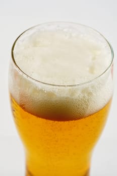 Glass of beer closeup on a white background