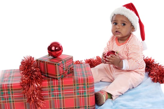 Adorable baby girl with christmas presents and santa hat