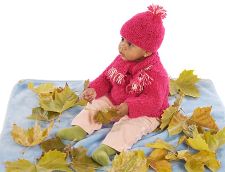 Cute toddler girl playing with fallen leaves