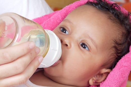 Adorable baby drinking a bottle - focus in the face -